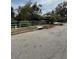 View of a residential street with a drainage grate and vegetation at 200 Carmona Ne Way, St Petersburg, FL 33704