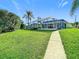 Landscaped backyard with walkway leading to canal at 4603 Topsail Trl, New Port Richey, FL 34652