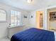 Bedroom with navy bedding, white dresser, and ensuite bath at 4603 Topsail Trl, New Port Richey, FL 34652