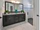 Modern bathroom with double vanity, large mirror, and a walk-in shower at 12609 Pensacola Ct, Riverview, FL 33579