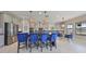 Modern kitchen with gray cabinets, stainless steel appliances, and an island with blue velvet chairs at 12609 Pensacola Ct, Riverview, FL 33579