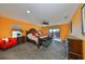 Bright main bedroom with king-size bed, orange walls, and access to a balcony at 12609 Pensacola Ct, Riverview, FL 33579