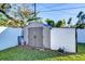 Gray storage shed with double doors in grassy backyard at 39142 Kendell Dr, Zephyrhills, FL 33542