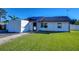 Front view of a single-story house with a small lawn and attached shed at 39142 Kendell Dr, Zephyrhills, FL 33542