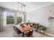 Bright dining room with wood table, pendant lighting, and natural light from large windows at 4539 San Martino Dr, Wesley Chapel, FL 33543