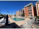 Community swimming pool surrounded by lounge chairs and a well-maintained apartment complex with a blue sky backdrop at 6960 20Th N Ave # 501, St Petersburg, FL 33710