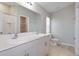 Bathroom boasts double sinks, a vanity with light gray cabinets, and a toilet at 7663 Peace Lily Ave, Wesley Chapel, FL 33545