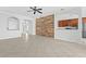 Large living room featuring a wood accent wall and tile floors at 7860 Atwood Dr, Wesley Chapel, FL 33545