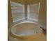 Oval bathtub with corner windows and mini blinds for privacy at 8216 Carriage Pointe Dr, Gibsonton, FL 33534