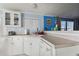 A galley kitchen with white cabinets, a corner sink, and a dishwasher at 8532 Fantasia Park Way, Riverview, FL 33578