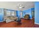 Living room with hardwood floors, blue walls, and ceiling fan at 8532 Fantasia Park Way, Riverview, FL 33578