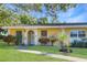 Single-story home with yellow exterior and landscaped yard at 883 De Soto Ct, Dunedin, FL 34698