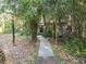 Wooden walkway leads to home through lush bamboo and foliage at 15577 Little Ranch Rd, Spring Hill, FL 34610