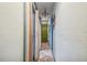 A long hallway with tiled floors and a painted green door at 15577 Little Ranch Rd, Spring Hill, FL 34610