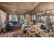 A cluttered living room with wood paneling and access to a backyard at 15577 Little Ranch Rd, Spring Hill, FL 34610