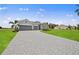 Two-story house with gray siding, stone accents, and a three-car garage at 17357 Comingo Ln, Punta Gorda, FL 33955