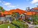 Community clubhouse with attractive landscaping and Spanish tile roof at 18106 Peregrines Perch Pl # 5204, Lutz, FL 33558