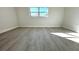 Bright bedroom with grey wood-look flooring and a large window at 212 Francis Dr, Apollo Beach, FL 33572
