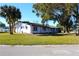 White single story home with a large front yard and mature trees at 212 Francis Dr, Apollo Beach, FL 33572