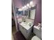 The clean, functional bathroom features purple walls and a modern vanity with sink at 2960 59Th S St # 411, Gulfport, FL 33707