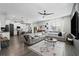 Open living room featuring a sectional sofa, a large TV, and a view into the kitchen at 3106 W Hartnett Ave, Tampa, FL 33611