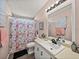 Clean bathroom with floral shower curtain and updated vanity at 37701 Rio Ln, Zephyrhills, FL 33541