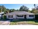 White brick ranch home with a gray roof, showcasing a well-maintained lawn and driveway at 4510 W Mcelroy Ave, Tampa, FL 33611