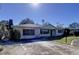 White brick ranch home with a gray roof, showcasing a well-maintained lawn and driveway at 4510 W Mcelroy Ave, Tampa, FL 33611