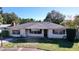 White brick ranch home with a gray roof, showcasing a well-maintained lawn and driveway at 4510 W Mcelroy Ave, Tampa, FL 33611