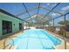 Relaxing screened-in pool with sunny exposure, blue water and neutral toned pool deck at 5224 Courtland Rd, Spring Hill, FL 34608