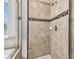 Large shower with beige tile and a decorative mosaic accent at 5344 Little Stream Ln, Wesley Chapel, FL 33545