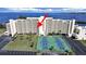 Aerial view of condo building with tennis courts, parking, and scenic bay views at 5915 Sea Ranch Dr # 408, Hudson, FL 34667