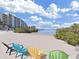 Beach with colorful chairs and a distant building at 5915 Sea Ranch Dr # 408, Hudson, FL 34667
