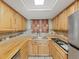 Well-lit kitchen boasts wood cabinets, laminate counters, and a stainless steel sink at 5915 Sea Ranch Dr # 408, Hudson, FL 34667