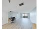Bright, open-concept living room features wood-look floors and access to a private balcony at 5915 Sea Ranch Dr # 408, Hudson, FL 34667