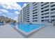 Gorgeous outdoor pool and sun deck with beautiful condominium building in the background at 5915 Sea Ranch Dr # 408, Hudson, FL 34667