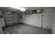 Attached garage space with overhead lighting, side door, and storage at 6906 Quail Hollow Blvd, Wesley Chapel, FL 33544