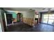 Open concept living room with dark floors, wall damage, and entrance to the kitchen at 6906 Quail Hollow Blvd, Wesley Chapel, FL 33544