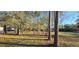 A side view of a home featuring the property's mature trees and a car in the driveway at 6906 Quail Hollow Blvd, Wesley Chapel, FL 33544