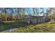 A rear exterior view of the home, set amongst trees, includes visible utilities at 6906 Quail Hollow Blvd, Wesley Chapel, FL 33544