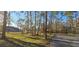 Street view of the parcel with a house in the distance along a grassy, tree-lined road at 6906 Quail Hollow Blvd, Wesley Chapel, FL 33544
