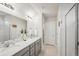 Double vanity bathroom with gray cabinets and a large shower at 8614 Mercator Ct, Parrish, FL 34219