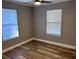 Bright bedroom with two windows, wood-look flooring, and ceiling fan at 1221 E Curtis St, Tampa, FL 33603