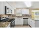 Modern kitchen featuring granite countertops, stainless steel appliances, and white shaker cabinets at 1424 Basswood Dr, Holiday, FL 34690