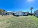 Exterior view of a mobile home with a yard and additional building at 18675 Us Highway 19 N # 232, Clearwater, FL 33764