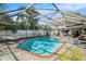 Screened pool with brick coping and a hammock at 3069 Pin Oak Dr, Clearwater, FL 33759