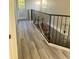 Upstairs hallway with wood-look floors and metal railing at 4015 Woodacre Ln, Tampa, FL 33624