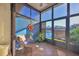 Relaxing sunroom with wicker chair, lake view, and blue accent wall at 4542 Park Lake N Ter # 4542, Bradenton, FL 34209