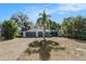 Gray house with white accents, paved driveway, and palm tree in the front yard at 6050 Waycross Dr, Spring Hill, FL 34606