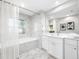 Modern bathroom with white cabinets and marble tile at 695 Sandy Hook Rd, Palm Harbor, FL 34683